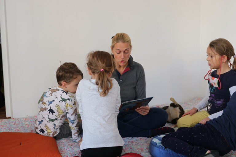 Julia Koller, Inhaberin der Lesewerkstatt liest Kinder in der Spielgruppe in Wien vor